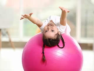 Child with motor delays participating in physical therapy