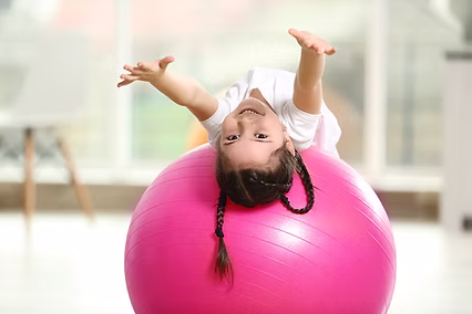 Child with motor delays participating in physical therapy